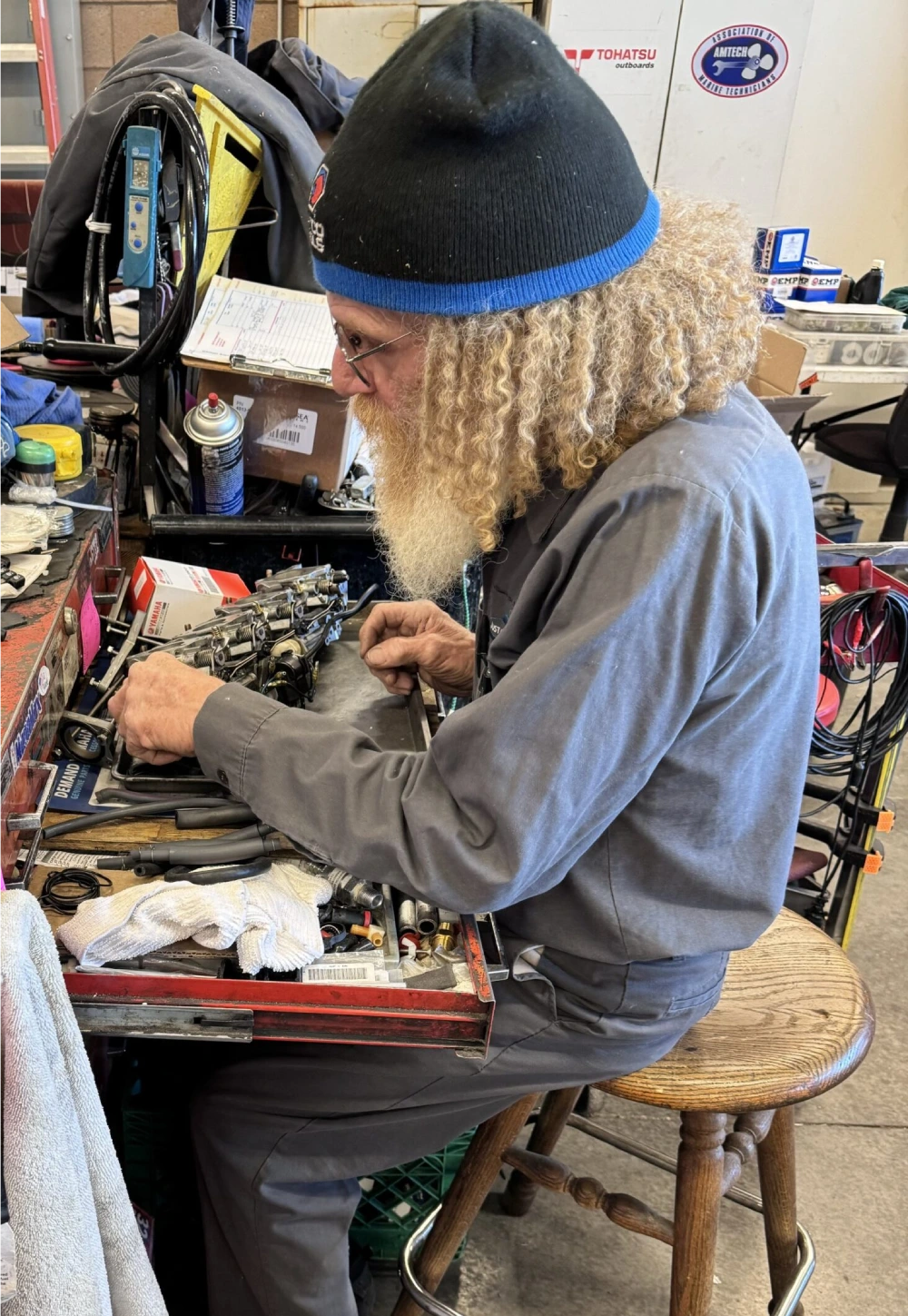 A man with long hair and beard working on something.